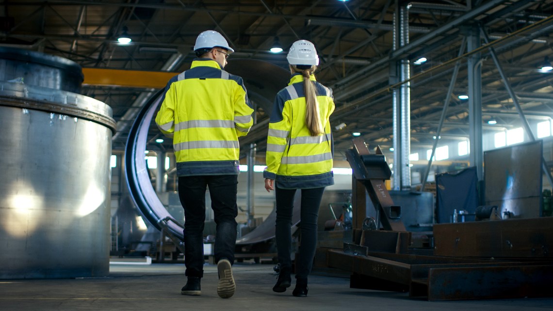 Two workers seen from the back in an industrial environment